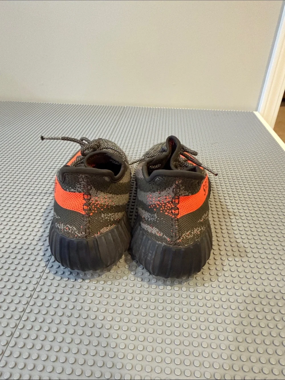 Yeezy men’s Black Knit Sneakers with Bright Orange Stripe